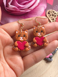 67b9ea7598f8a707689a5b69_catsholdingheart-orange_1770361366476.jpg